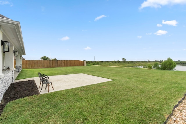 view of yard with a water view and a patio area