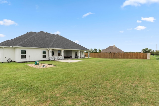 rear view of house featuring a lawn and a patio