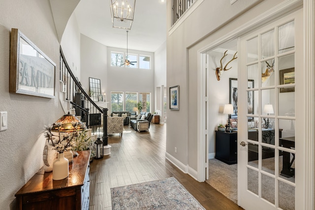 foyer entrance featuring french doors, dark hardwood / wood-style flooring, and a high ceiling