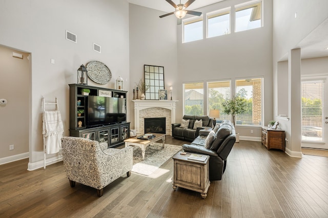 living room featuring hardwood / wood-style flooring, ceiling fan, and a high ceiling