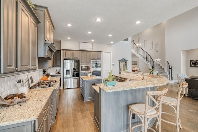 kitchen featuring light stone countertops, a large island, sink, and stainless steel appliances