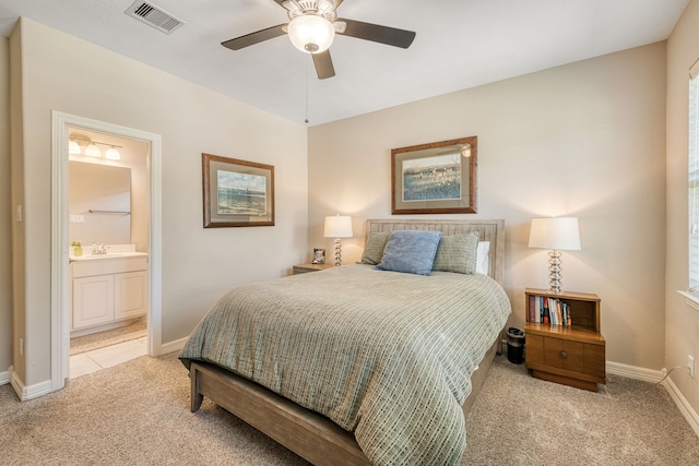 carpeted bedroom with connected bathroom, ceiling fan, and sink