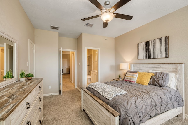 bedroom with light carpet, ensuite bath, and ceiling fan