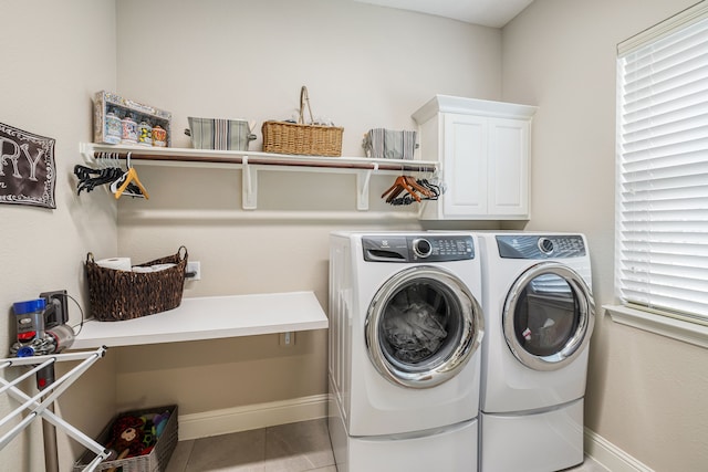 laundry room with washer and dryer, cabinets, and light tile patterned floors