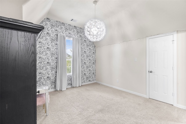 interior space with an inviting chandelier, lofted ceiling, and carpet