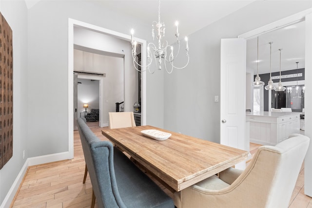 dining room with a notable chandelier and light wood-type flooring