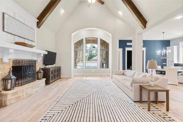 living room with beam ceiling, a fireplace, and light hardwood / wood-style floors