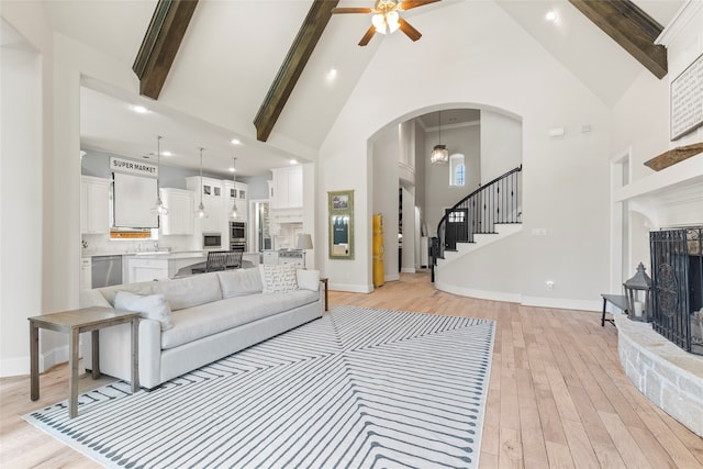 living room featuring beam ceiling, high vaulted ceiling, light wood-type flooring, and ceiling fan