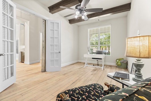 living area with light hardwood / wood-style floors, beamed ceiling, and ceiling fan