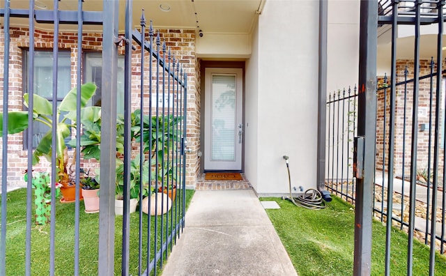 view of exterior entry featuring a yard