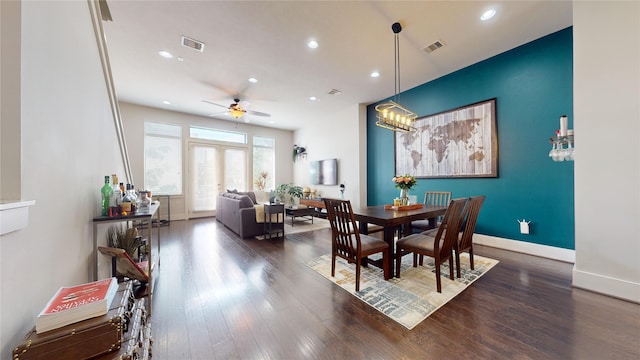 dining area with ceiling fan with notable chandelier and dark wood-type flooring