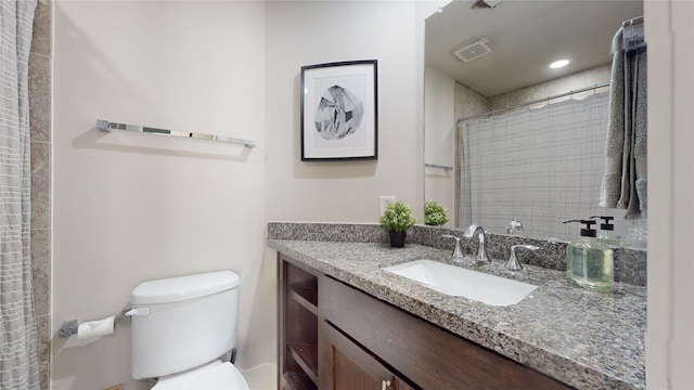 bathroom featuring curtained shower, vanity, and toilet