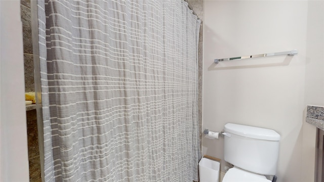 bathroom featuring toilet and a shower with curtain