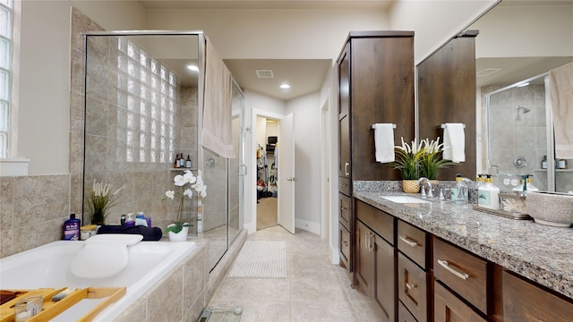 bathroom featuring vanity, plus walk in shower, and tile patterned flooring