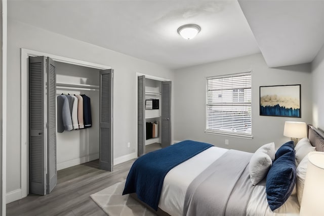 bedroom featuring multiple closets and hardwood / wood-style flooring