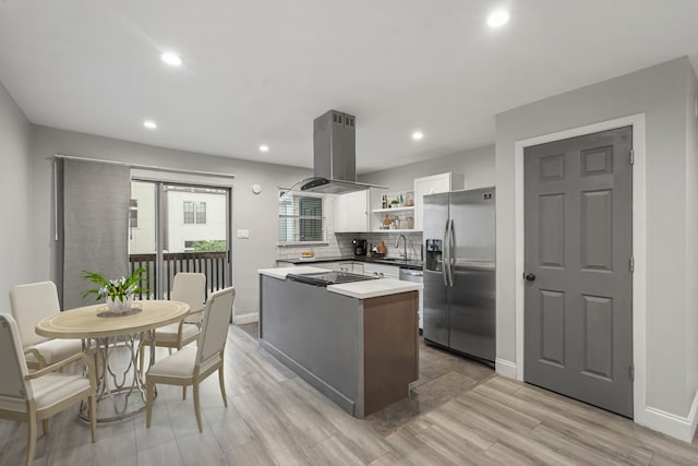 kitchen with white cabinets, island range hood, a center island, light hardwood / wood-style flooring, and stainless steel fridge with ice dispenser