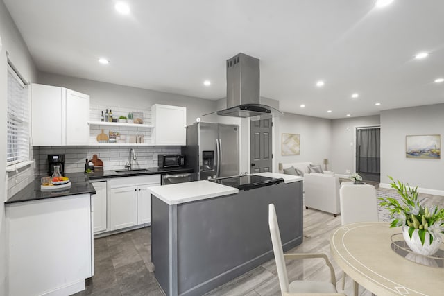 kitchen featuring sink, island exhaust hood, white cabinetry, black appliances, and a center island