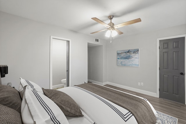 bedroom featuring ceiling fan, hardwood / wood-style flooring, and connected bathroom