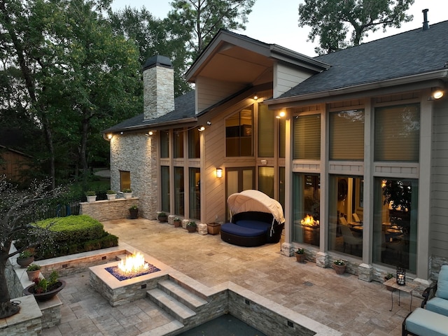 rear view of house with a patio and an outdoor fire pit