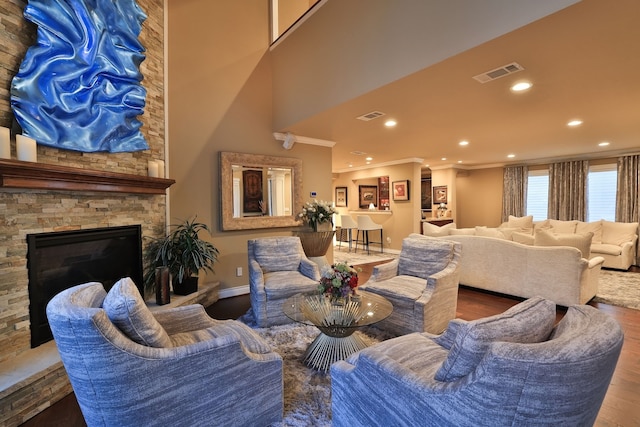 living room featuring crown molding, a fireplace, and hardwood / wood-style flooring