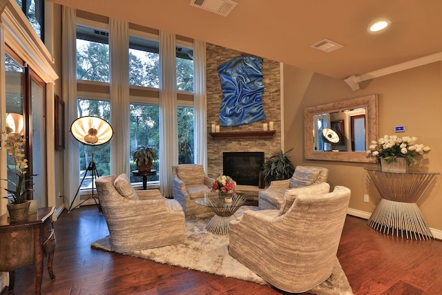 living room with crown molding, a fireplace, and dark wood-type flooring