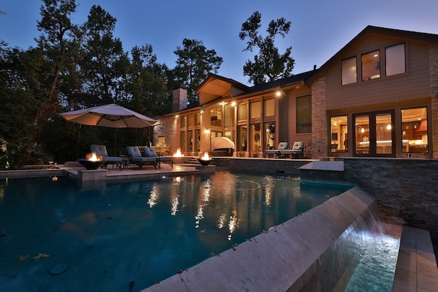 pool at dusk featuring a patio