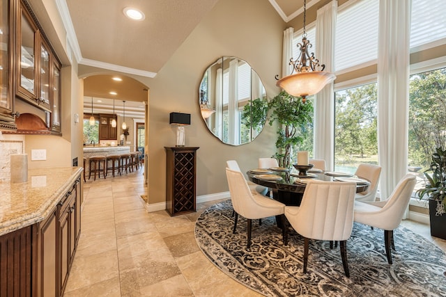 dining area featuring ornamental molding and vaulted ceiling