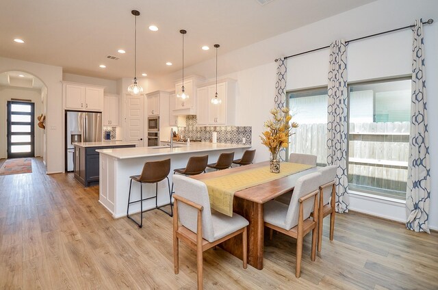 dining space with light wood-type flooring and sink