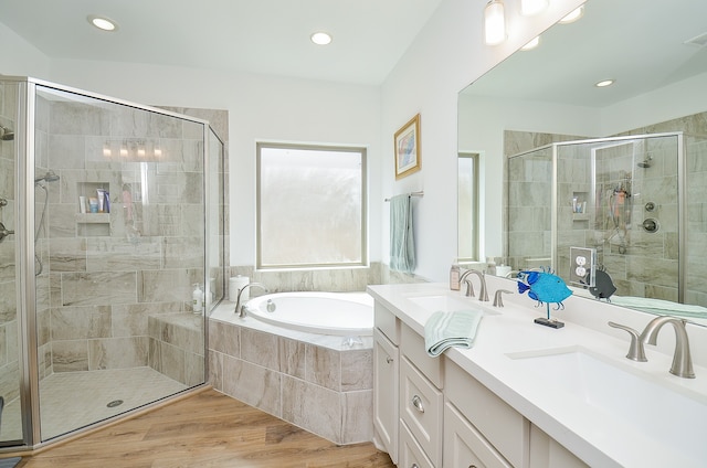 bathroom featuring wood-type flooring, vanity, and plus walk in shower