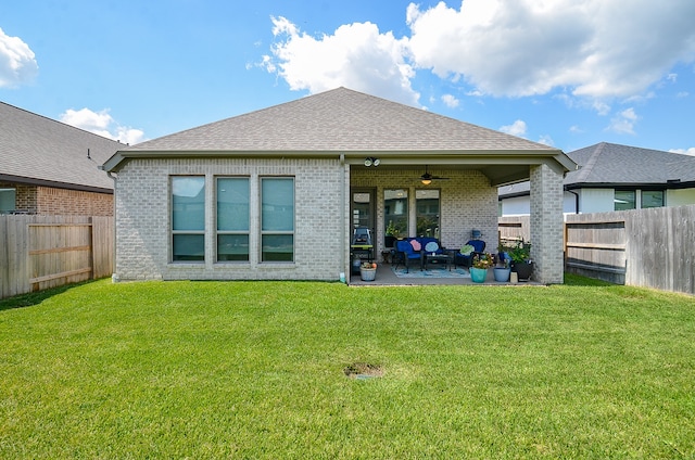 back of house featuring a lawn, ceiling fan, and a patio