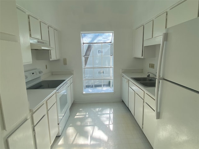 kitchen with white cabinets, light tile patterned floors, white appliances, and a wealth of natural light