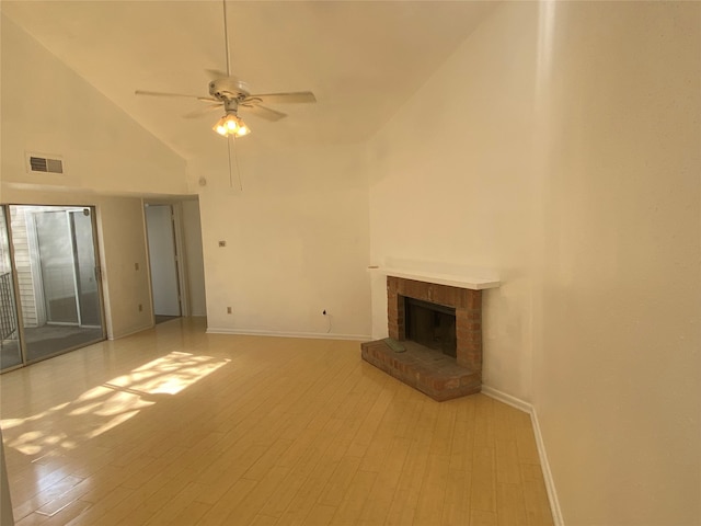 unfurnished living room with light wood-type flooring, high vaulted ceiling, ceiling fan, and a brick fireplace