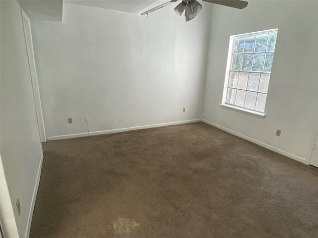 unfurnished room featuring ceiling fan and dark colored carpet