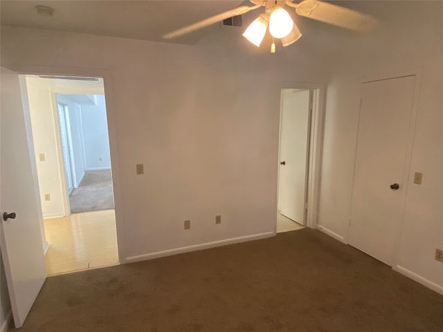 unfurnished bedroom featuring ceiling fan and dark carpet