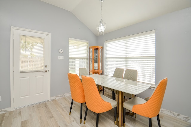 dining space featuring light wood-type flooring, vaulted ceiling, and plenty of natural light