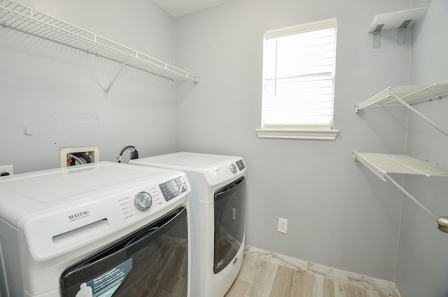 laundry area featuring light hardwood / wood-style flooring and washing machine and dryer