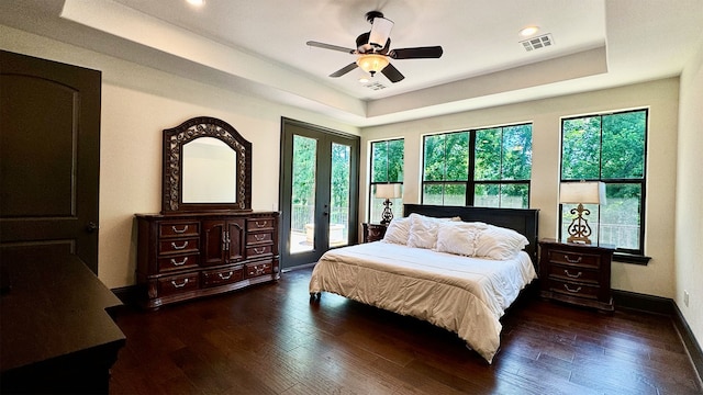 bedroom featuring access to exterior, dark hardwood / wood-style flooring, multiple windows, and ceiling fan