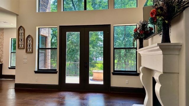 doorway with french doors, a towering ceiling, and dark hardwood / wood-style floors