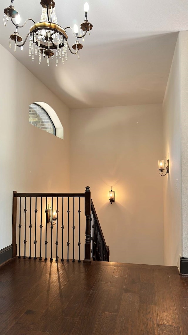 staircase with wood-type flooring and a chandelier