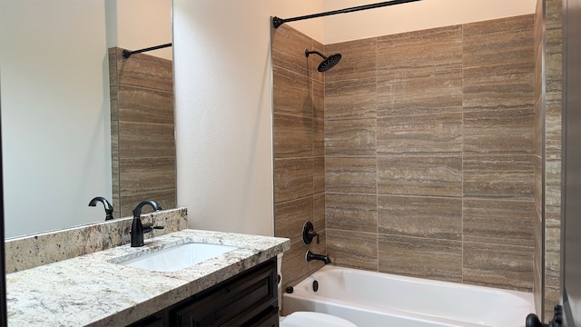 full bathroom featuring tiled shower / bath combo, toilet, and vanity