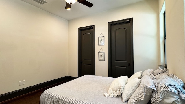 bedroom with dark hardwood / wood-style floors and ceiling fan