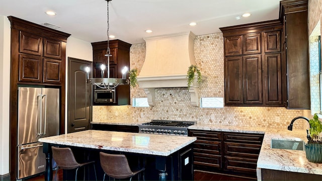 kitchen featuring decorative backsplash, a kitchen bar, stainless steel appliances, and light stone counters