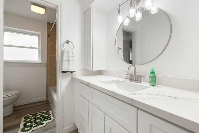 full bathroom featuring vanity, toilet, tiled shower / bath, and hardwood / wood-style flooring