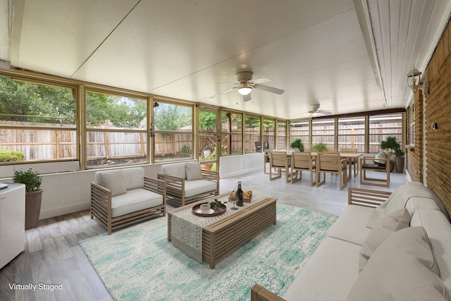 sunroom / solarium with vaulted ceiling, a wealth of natural light, and ceiling fan