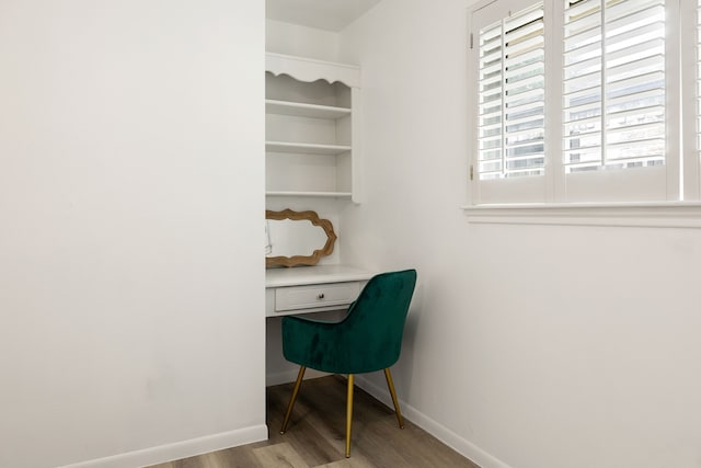 office space with built in desk and light wood-type flooring