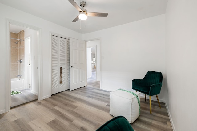 living area with light hardwood / wood-style floors and ceiling fan