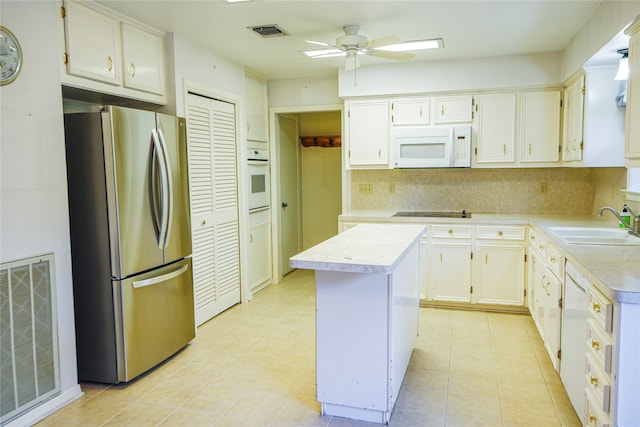 kitchen featuring white appliances, a center island, tasteful backsplash, ceiling fan, and sink