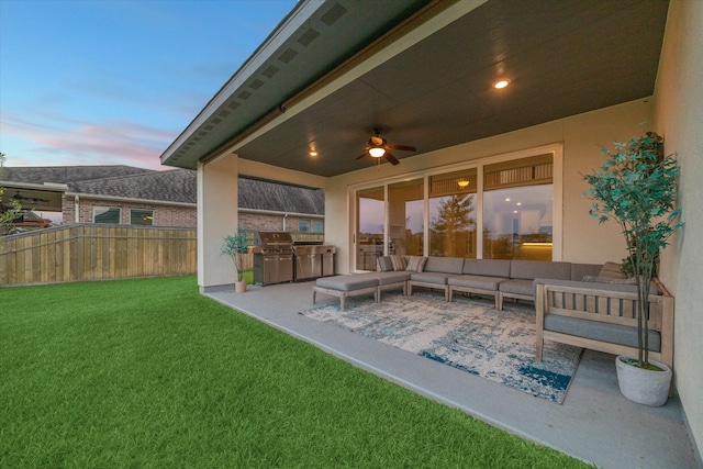 patio terrace at dusk featuring outdoor lounge area, a lawn, ceiling fan, and grilling area