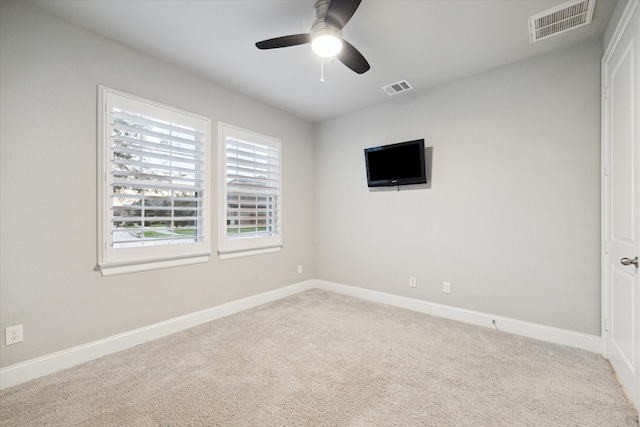 empty room with ceiling fan and carpet flooring