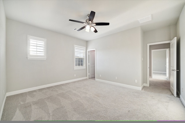 unfurnished room with light colored carpet and ceiling fan